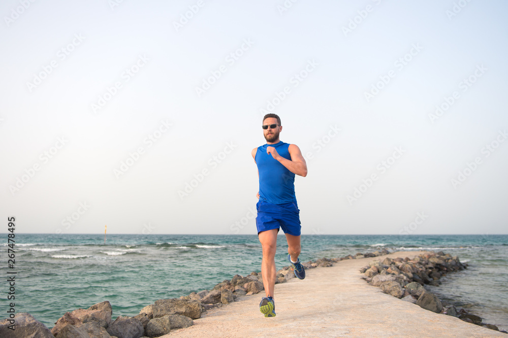 man in sportswear running on sea coast. future success. successful runner. summer activity. sport recreation. healthy lifestyle. run for success. Towards success. practices sport running for life