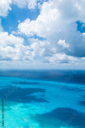 Blue sky with white clouds over turquoise sea