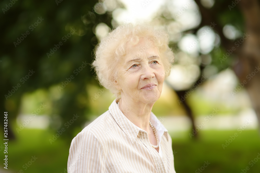 Outdoor portrait of beautiful senior woman with curly white hair. Outdoor portrait of beautiful senior woman with curly white hair.