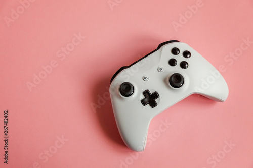 White joystick gamepad, game console on pastel pink colourful trendy modern pin-up background. Computer gaming competition videogame control confrontation concept. Cyberspace symbol