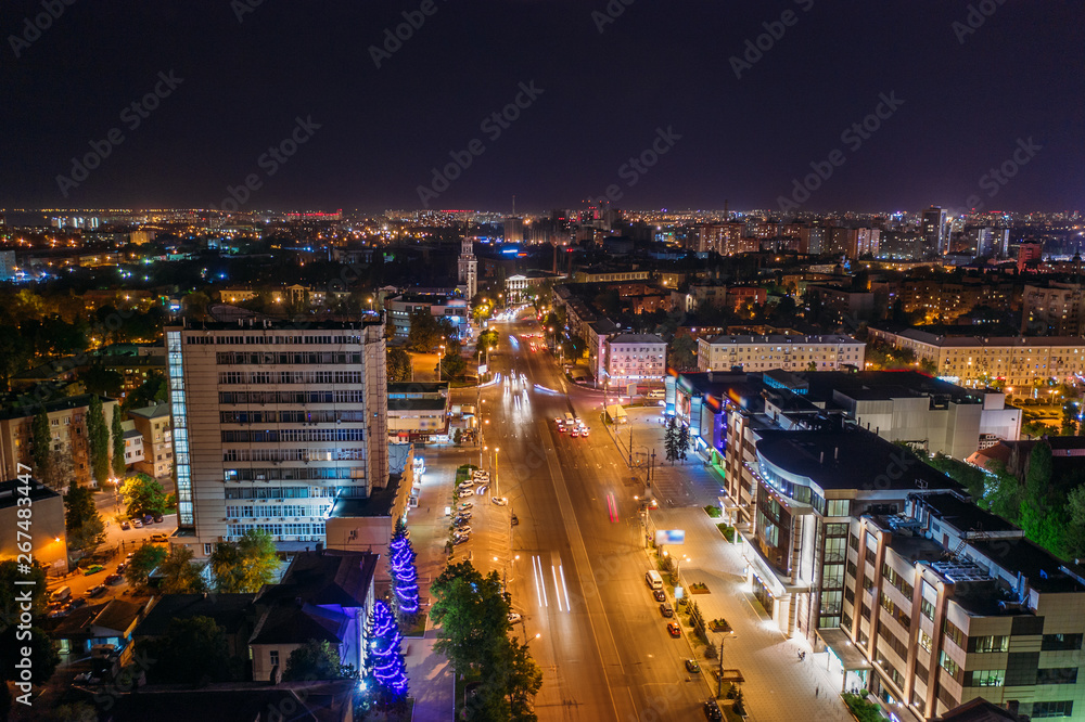 Aerial view of night city Voronezh downtown with illuminated buildings, malls, roads with car traffic, drone photo