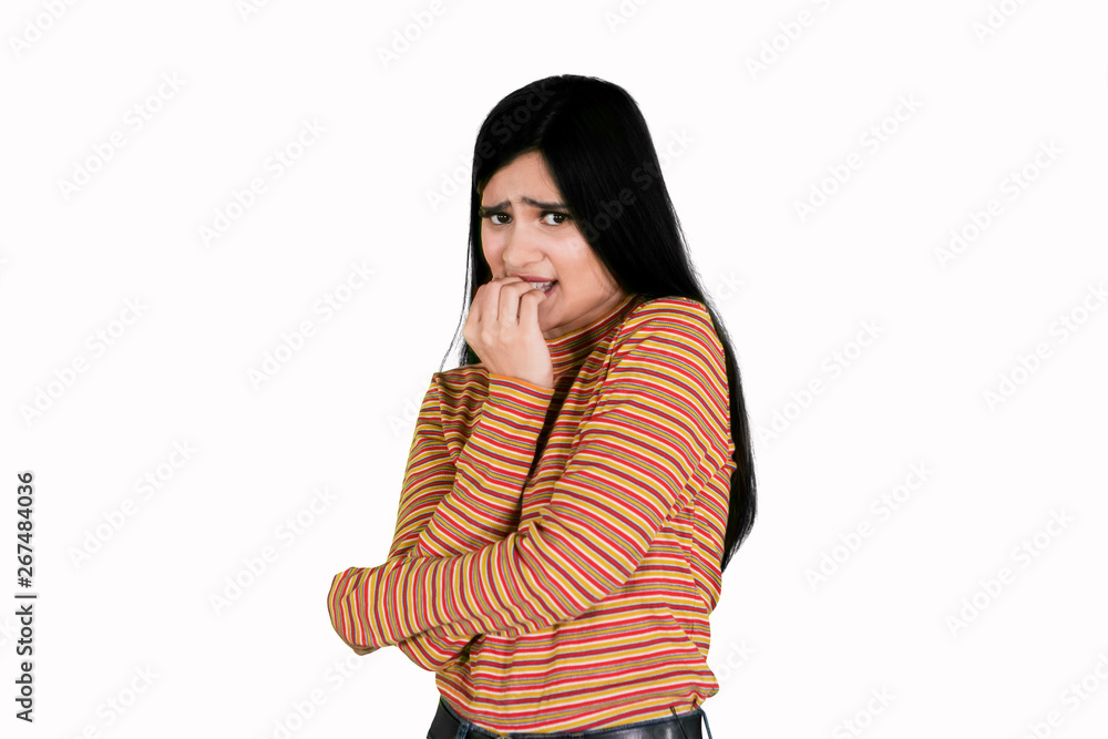 Afraid young woman biting her finger on studio Afraid young woman biting her finger on studio