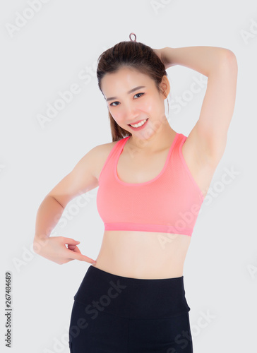 beautiful portrait young asian woman in sport clothing pointing waist with satisfied and confident isolated on white background, girl asia have shape and wellness, exercise fit with health concept. © N_studio