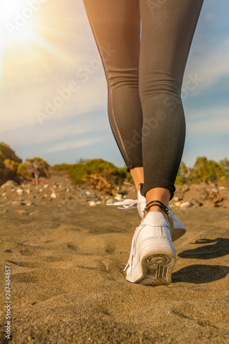 young fitness woman jogging at sunrise/sunset beach