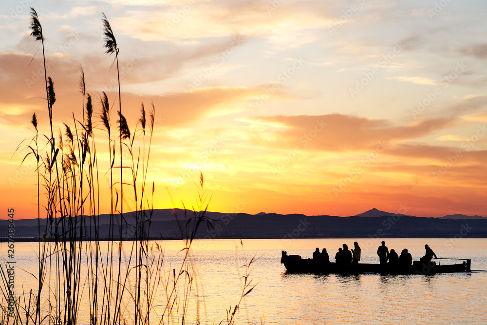Silueta de un grupo de personas paseando en barca por la Albufera de Valencia Silueta de un grupo de personas paseando en barca por la Albufera de Valencia