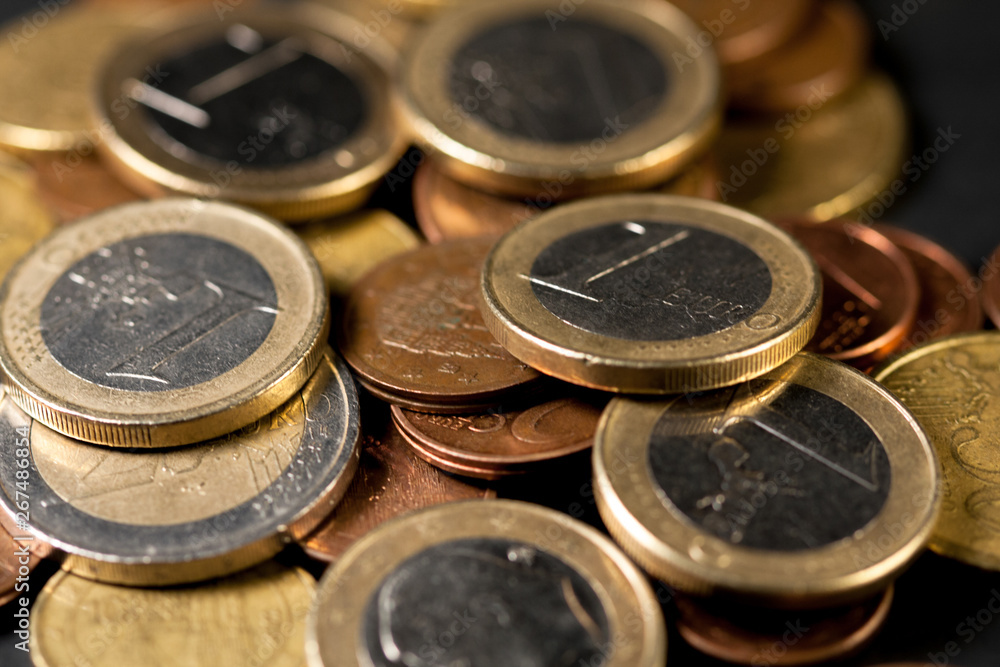Different amounts of scattered European coins on a black background. Different amounts of scattered European coins on a black background.