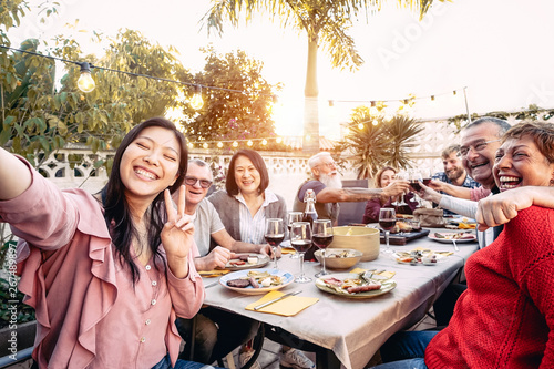 Canvas Print Happy family cheering and toasting with red wine glasses at dinner outdoor - Peo