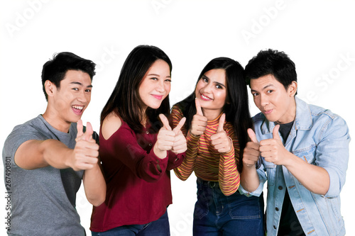 Happy young people show thumbs up on studio