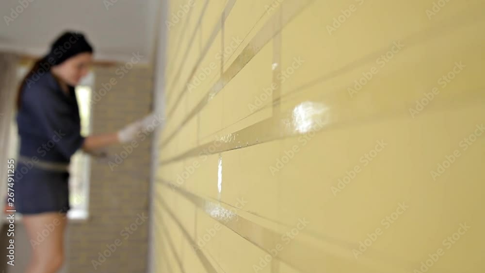 Reconstruction of the house,construction of a Young woman putty walls of the house in the apartment before painting the window Reconstruction of the house,construction of a Young woman putty walls of the house in the apartment before painting the window