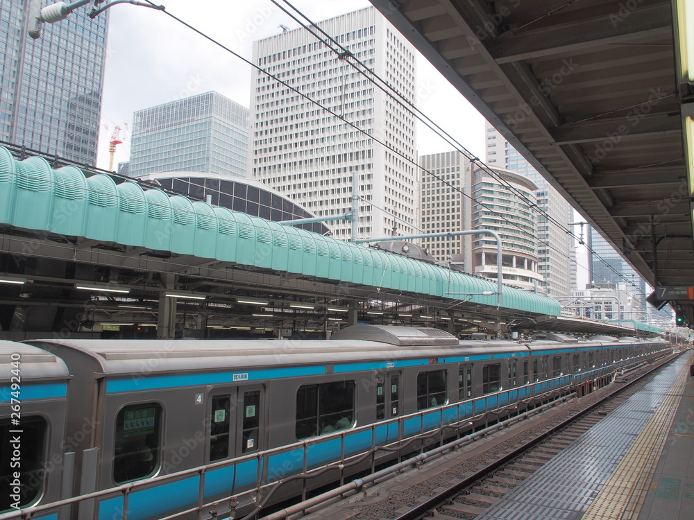 View from the railway platform of Tokyo Train Station with modern office towers under blue sky View from the railway platform of Tokyo Train Station with modern office towers under blue sky