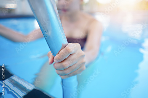 Wallpaper Mural Hand woman hold grab bars in the pool. Torontodigital.ca