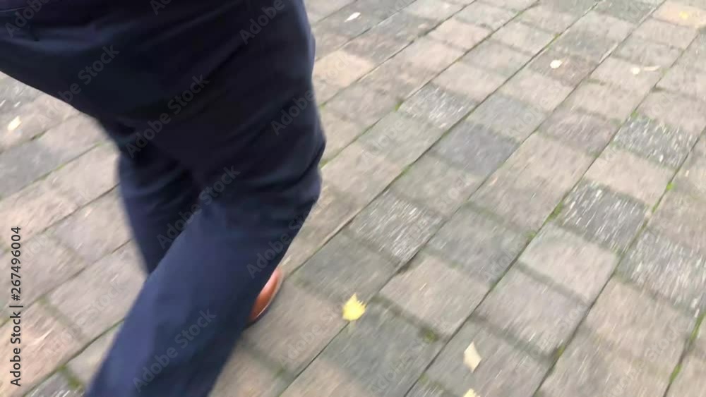 SLOW MOTION: Man walking down some stairs on a paved surface SLOW MOTION: Man walking down some stairs on a paved surface