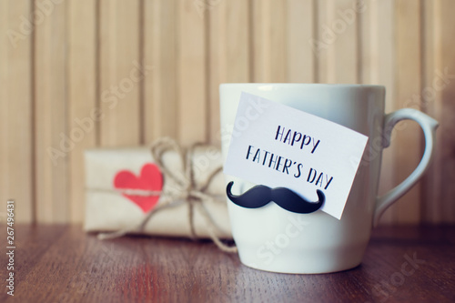 Fathers day. Greeting Message, Cup with funny mustache over wooden board.