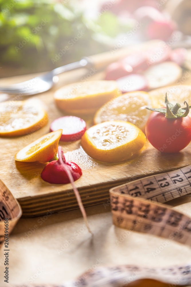 Healthy vegan food background with cutting board and lemon slices. Top view to organic food background with cutting board and lemon slices