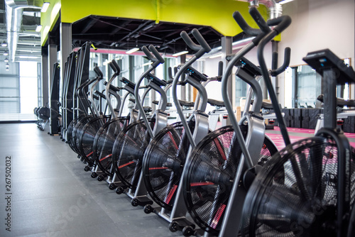 Row of elliptical bikes or assault air bikes in a gym or fitness Club