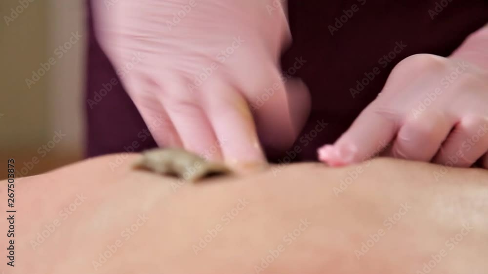 The young man removes the hair on the back of his head in a beauty salon. Epilation The young man removes the hair on the back of his head in a beauty salon. Epilation