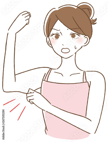二の腕をつまむ女性