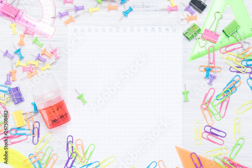 stationery objects lie around a blank white sheet, a place for an inscription