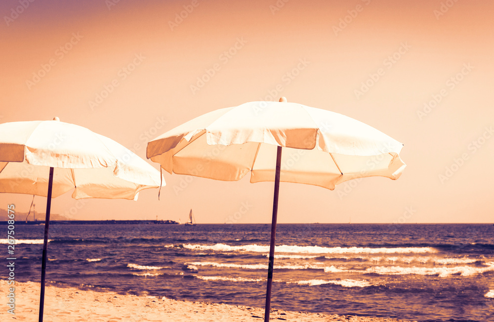 Sicily sunset, view of the beach of ionic sea near Catania, Lido Cled with white umbrellas