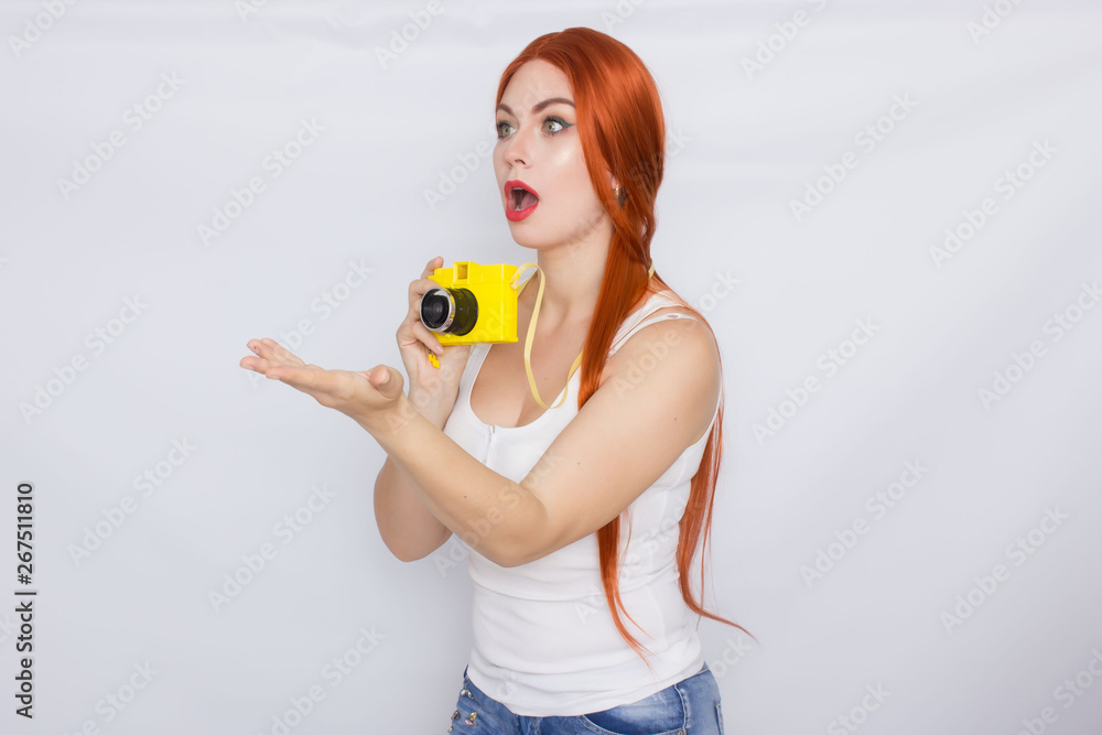 Redhead woman making photot and looking at yellow camera Redhead woman making photot and looking at yellow camera
