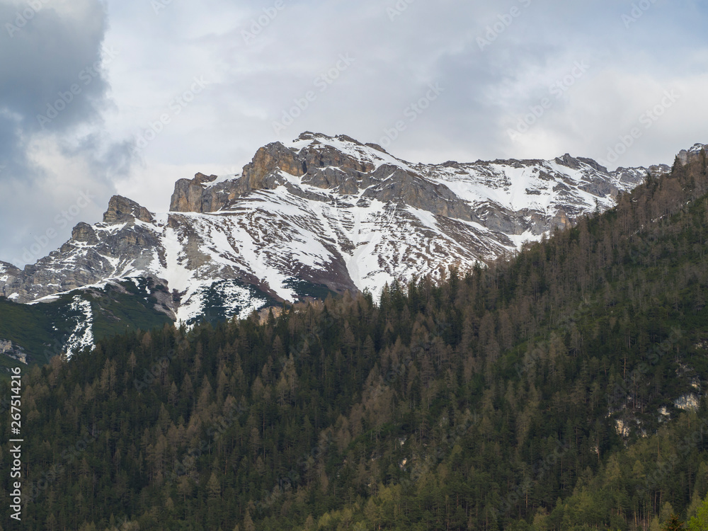 snow covered alpen mountain peaks and forest in Stubaital or Stubai Valley near Innsbruck, Tirol, Austria, dramatic clouds