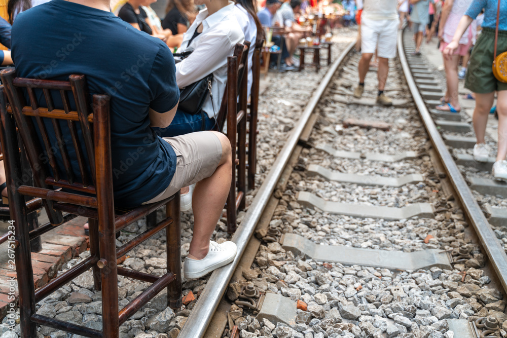 Railway cafe. People drink coffee or walking on railways waiting for train to arrive on railway road in Hanoi, Vietnam.