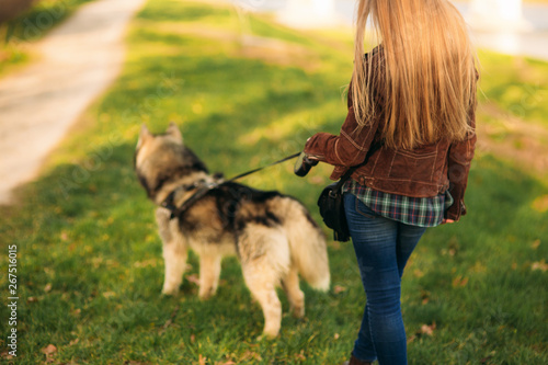Back view of blond hair woman walk with dog