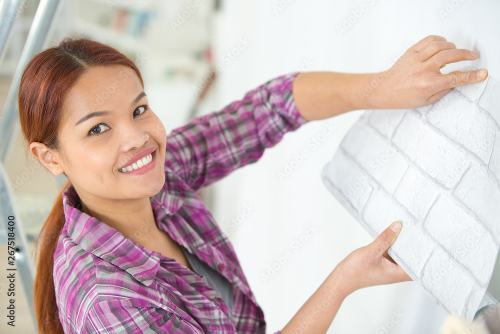 woman posing while holding wall paper