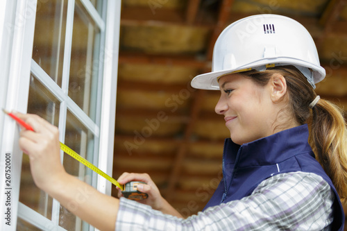 side view of professional window fitter measuring window