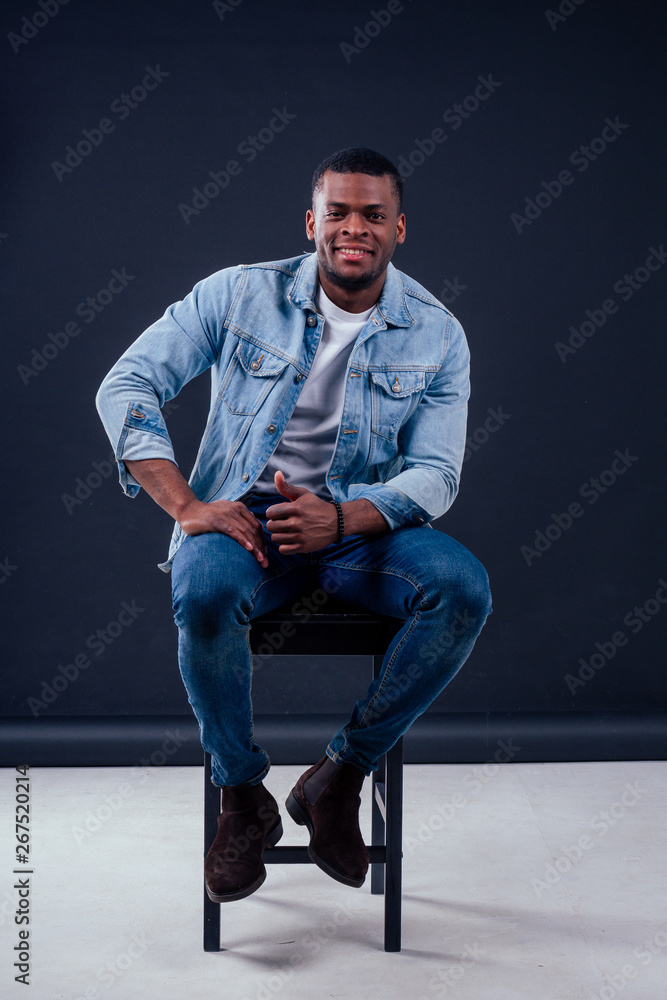 African American healthy male model in a cotton white t-shirt woth Jean jacket in studio summer lifestyle African American healthy male model in a cotton white t-shirt woth Jean jacket in studio summer lifestyle