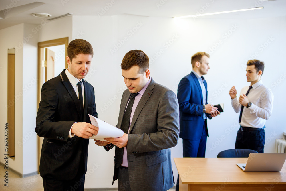 Businessman with his colleague stands with documents and discuss it. Businessman with his colleague stands with documents and discuss it.