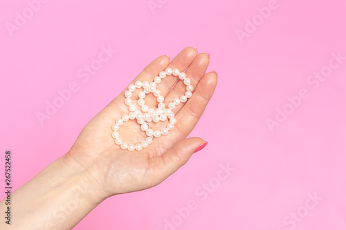 White pearl necklace on the woman's hand