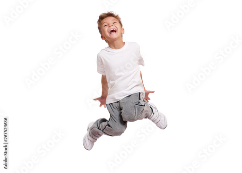 Adorable little boy smiling and jumping, isolated on white background. Shooting in the studio.