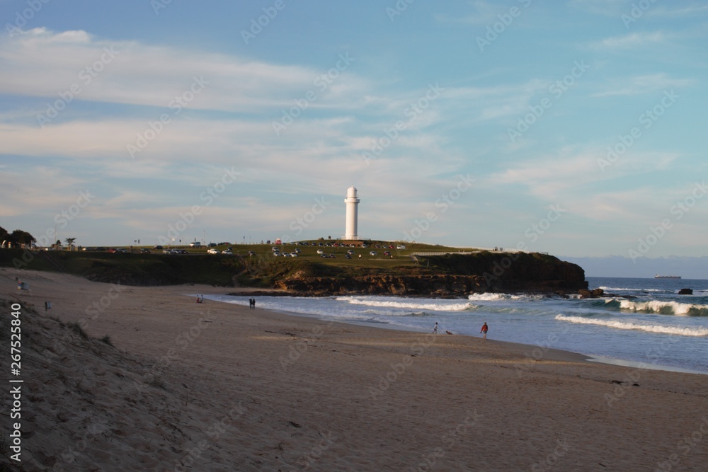 Australian beach view with a lighthouse on the horizon 
