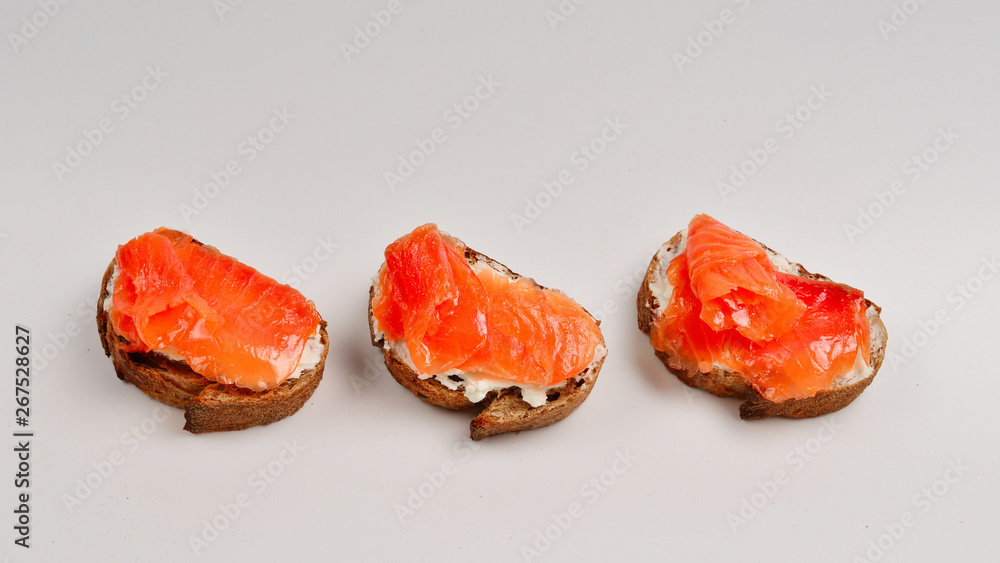 Salmon on a bread with cream isolated on white. Salmon on a bread with cream isolated on white.