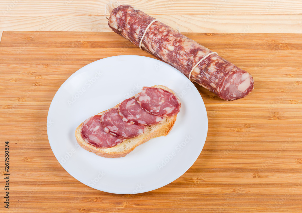 Open sandwich with dry-cured sausage and not sliced sausage Open sandwich with dry-cured sausage and not sliced sausage