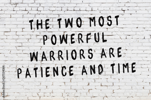 White brick wall with painted black motivational quote inscription