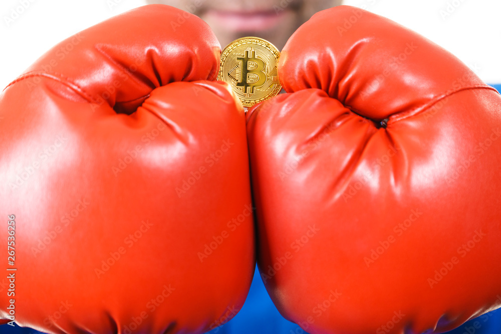 Man in boxing gloves holding bitcoin
