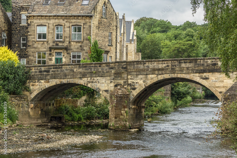 One of the oldest crossing points in the area, Ireland Bridge elegantly spans the River Aire at Bingley in Yorkshire, overlooked by Victorian houses