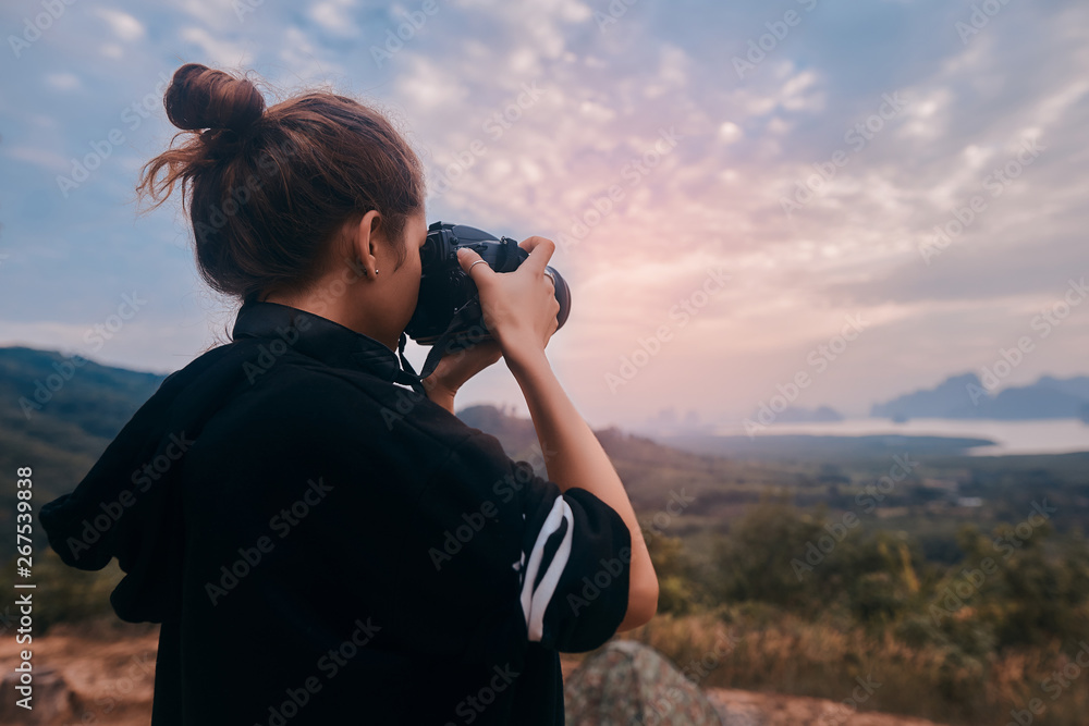 Rear view of a young woman photographer shooting the awesome view of Ao Phang Nga National Park Rear view of a young woman photographer shooting the awesome view of Ao Phang Nga National Park