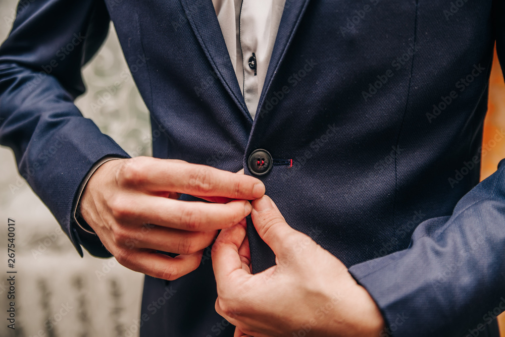 young man buttoning buttons on his jacket