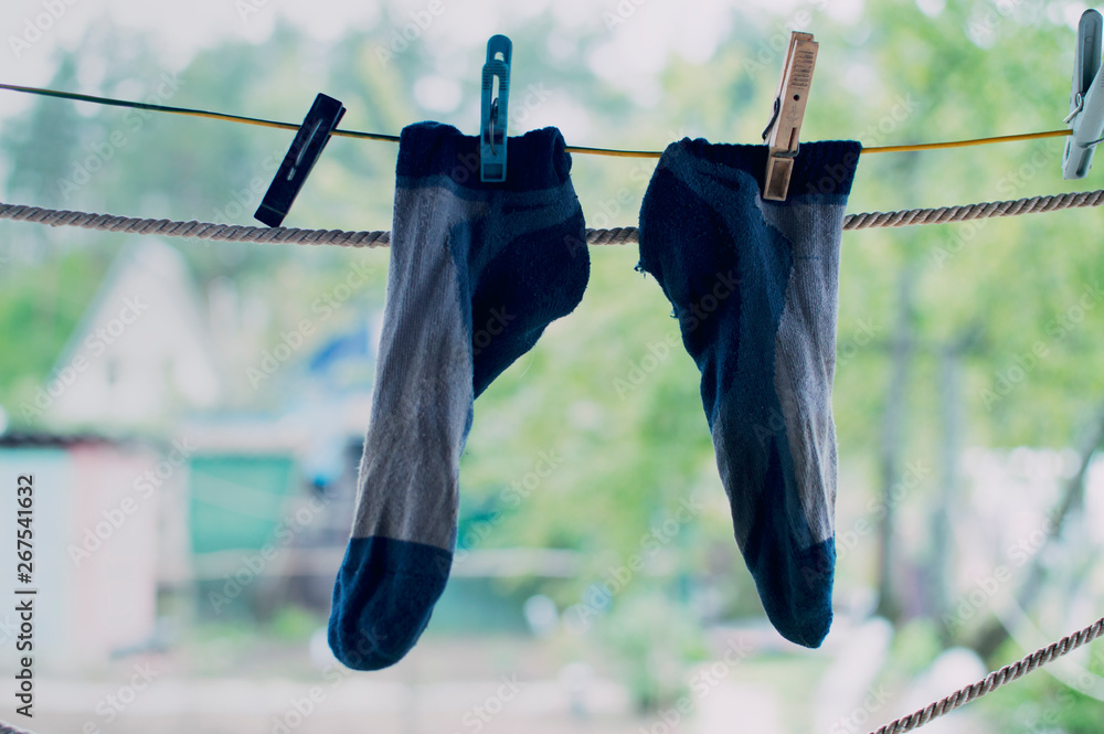 The washed socks are hung on the rope. Dry socks are dried on the street.Hanging  clothes drying outdoors Stock Photo