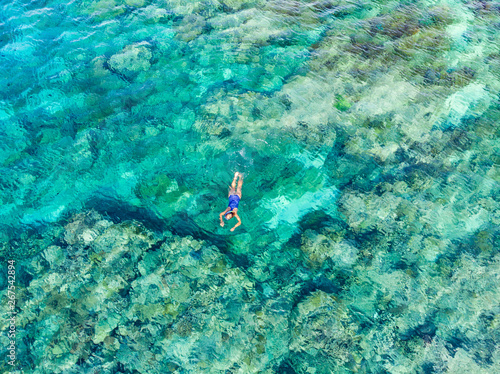 Aerial top down people snorkeling on coral reef tropical caribbean sea  turquoise blue water. Indonesia Wakatobi archipelago  marine national park  tourist diving travel destination