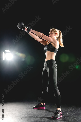 Young athletic girl performs swinging weight.