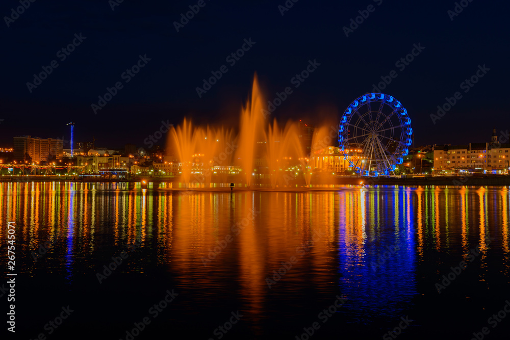 May 4, 2019: Evening cityscape with a bay, a fountain, a ferris wheel. Cheboksary. Russia.