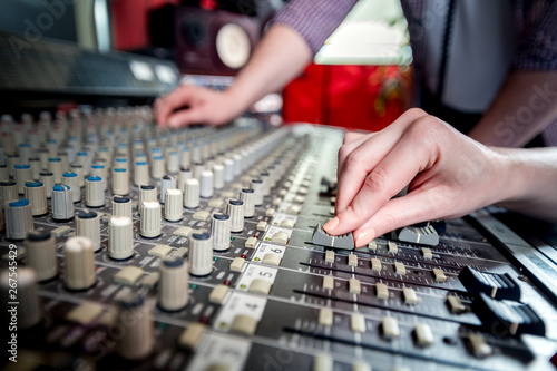 Music engineers working together in recording studio using mixing desk © leszekglasner