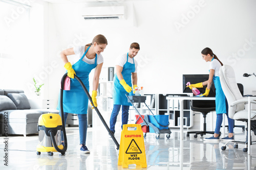 Team of janitors cleaning office