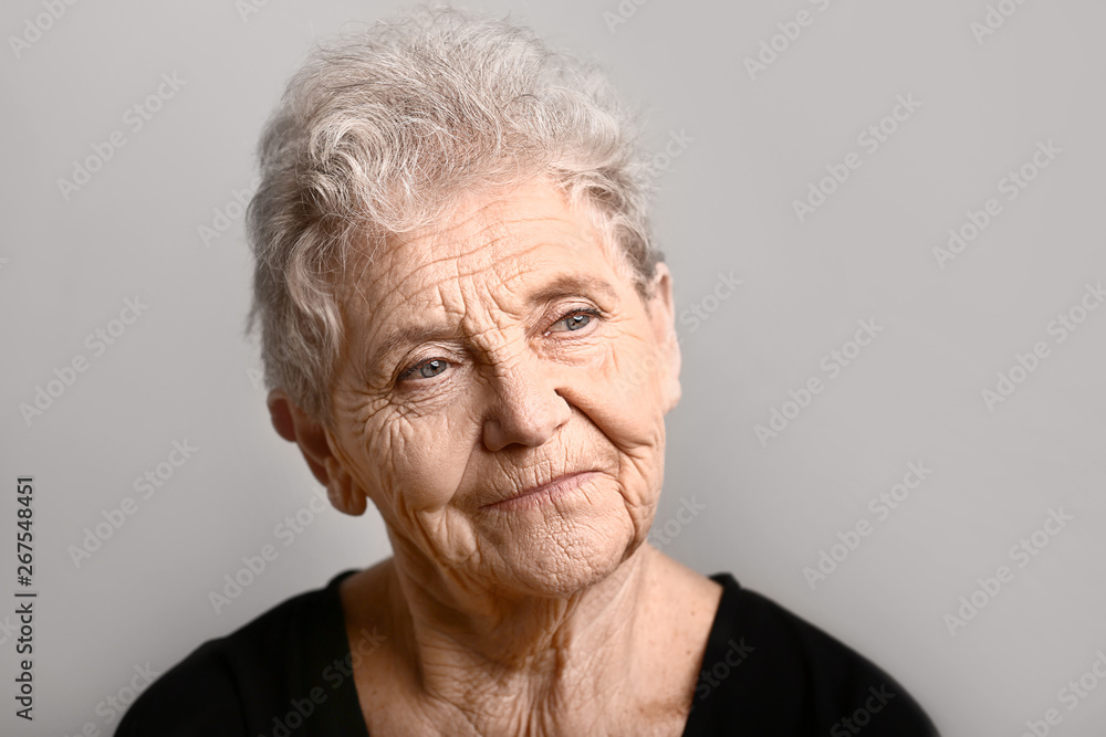 Portrait of senior woman on grey background Portrait of senior woman on grey background