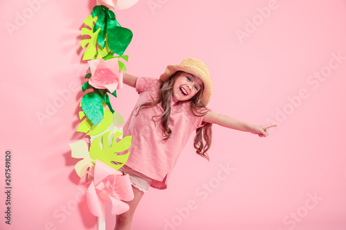 Little cute girl in summer hat on color background