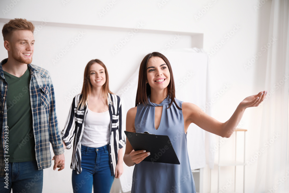 Obraz premium Real estate agent showing young couple a new house